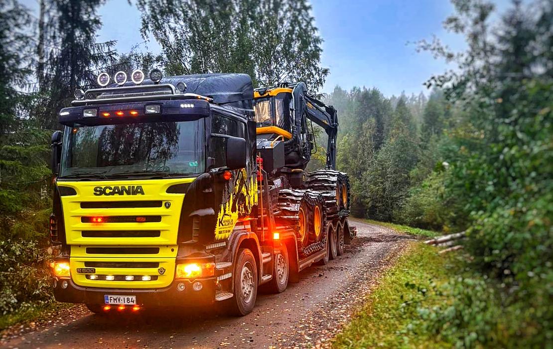 Mets&auml;kone kuljetettavana lavettirekalla ty&ouml;maalle soratiet&auml; pitkin.